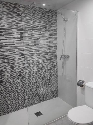 a bathroom with a glass shower with a toilet at Aparthotel Las Mariposas in Lloret de Mar