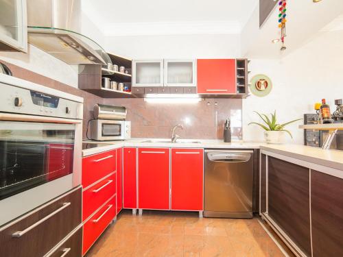 a kitchen with red cabinets and a sink at Villa Royal Dream in Sveti Stefan