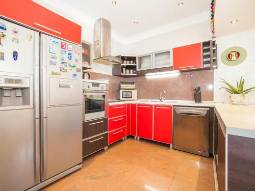 a kitchen with red cabinets and stainless steel appliances at Villa Royal Dream in Sveti Stefan