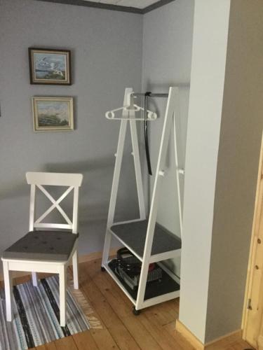 a room with a white shelf and a chair at B&B Hannåsa Gård in Hammenhög