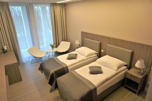 カミエン・ポモルスキにあるMieszko IIのベッド2台とテーブルが備わるホテルルームです。