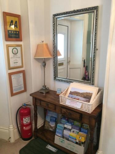 a mirror on top of a table with boxes on it at Invergarry Room Only Guest House For Adults in Windermere