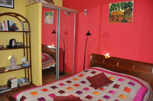 ラ・キャディエール・ダズールにあるLes Oliviers La Cadiereの赤い壁のベッドルーム1室(ベッド1台付)