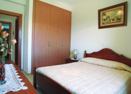 a bedroom with a bed and a cabinet and a table at Eve Pissouri Xιnisteri Villa in Pissouri