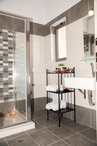 a bathroom with a shower and a towel rack next to a sink at Efrilias Studios & Apartments in Kissamos