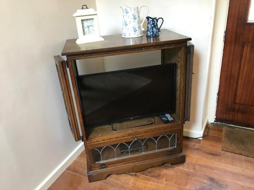 a television on a wooden stand in a room at Anglers rest in Millers Dale