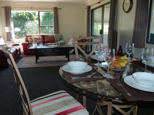 a living room with a table with plates and wine glasses at Tranquil Private Rural Retreat in Tauranga