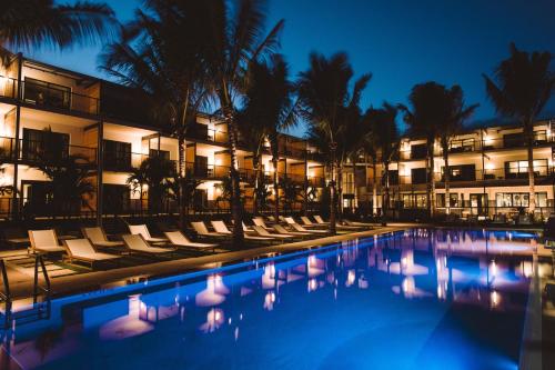 a hotel pool with chairs and palm trees at night at The Perry Hotel & Marina Key West in Key West