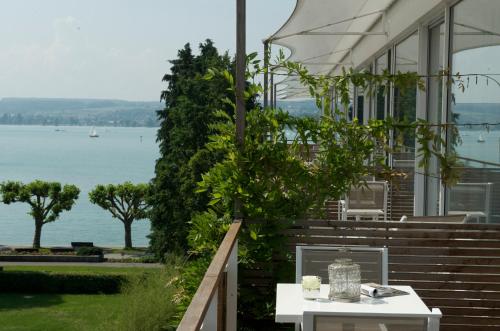 a table on the porch of a house overlooking the water at RIVA - Das Hotel am Bodensee in Konstanz