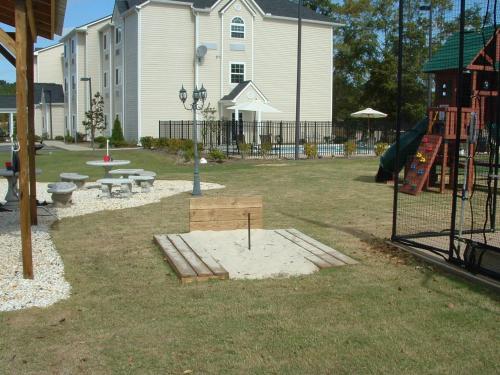 a park with a playground with benches and a slide at Microtel Inn & Suites by Wyndham Ozark in Ozark