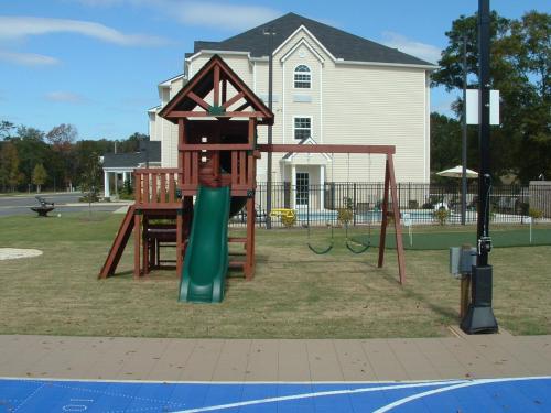 a playground with a swing set in front of a house at Microtel Inn & Suites by Wyndham Ozark in Ozark