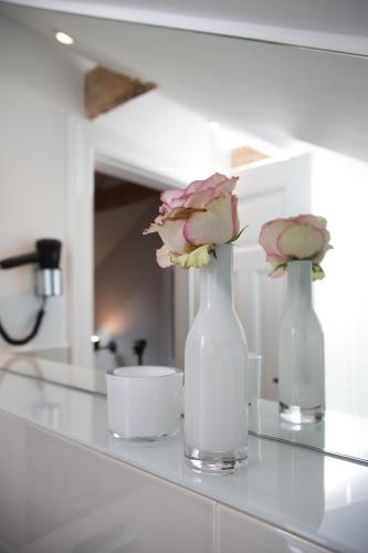two vases with flowers in them sitting on a counter at Das ELBCOTTAGE in Hamburg