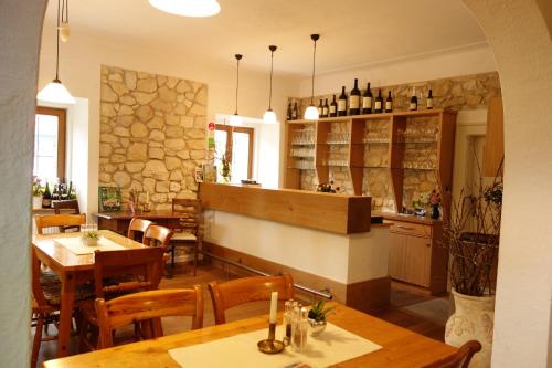 a restaurant with tables and chairs and a stone wall at Weingut Primus Südsteiermark in Spielfeld