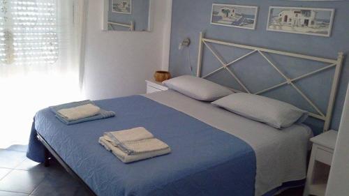 um quarto com uma cama azul com toalhas em B&B LA TERRAZZA em Marettimo