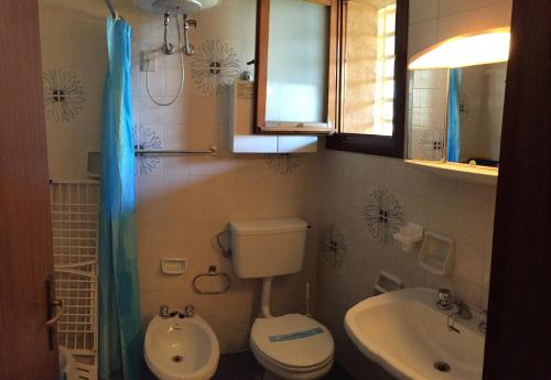 a small bathroom with a toilet and a sink at Fenice in Bibione