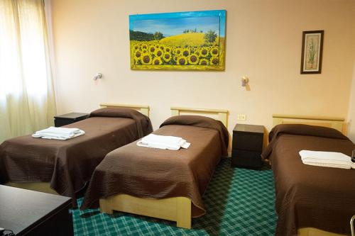 a room with three beds and a painting on the wall at Albergo Roma in Valdagno