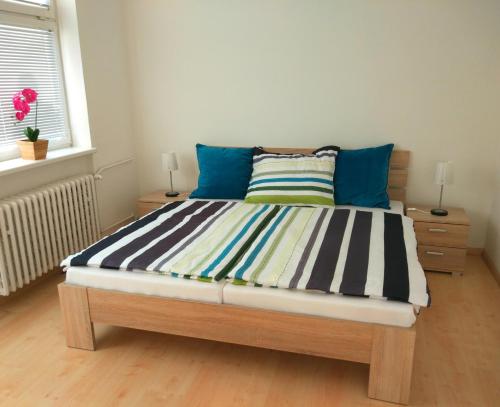 a bedroom with a large bed with blue pillows at Riverview Apartment Bratislava in Bratislava