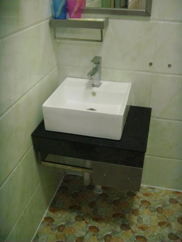 a bathroom with a white sink on a black counter at Qufu Garden Hotel in Qufu