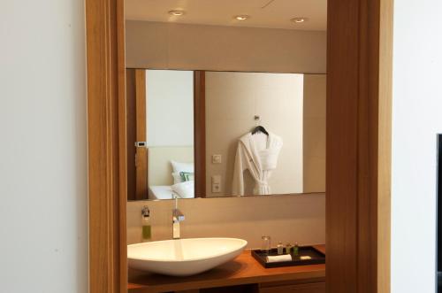 a bathroom with a sink and a mirror at RIVA - Das Hotel am Bodensee in Konstanz