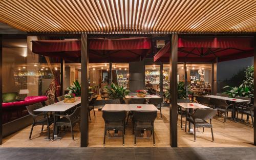 un ristorante con tavoli, sedie e ombrelloni rossi di Windsor Hotel Milano a Milano
