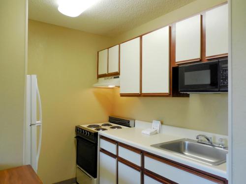 a kitchen with a sink and a stove and a microwave at Extended Stay America Suites - Daytona Beach - International Speedway in Daytona Beach
