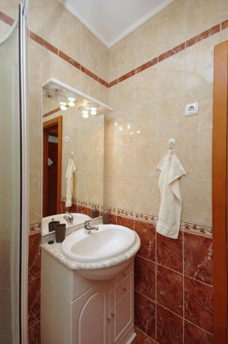 a bathroom with a sink and a mirror at Bíbor Apartman in Gyula
