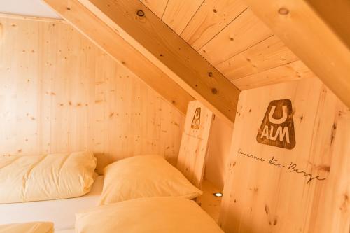 two beds in a small room with wooden walls at UALM Untermarkter Alm in Imst