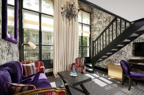 a living room with purple chairs and a piano at Le Pavillon de la Reine & Spa, Place des Vosges in Paris