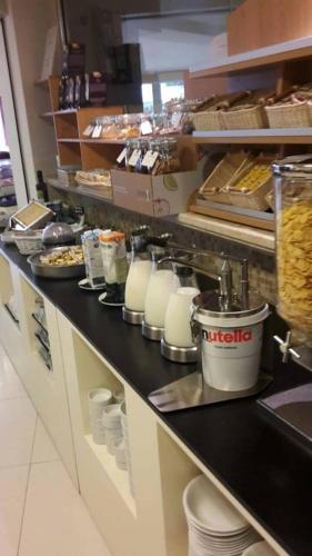 a kitchen with a counter with milk and food at Hotel Lady Mary in Milano Marittima