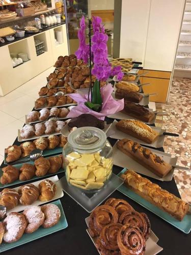a table filled with different types of pastries and desserts at Hotel Lady Mary in Milano Marittima