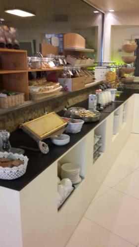 a kitchen with a counter with plates and food at Hotel Lady Mary in Milano Marittima