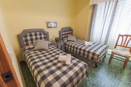 Playa de MiramarにあるPandora 2のベッド2台と椅子が備わる客室です。