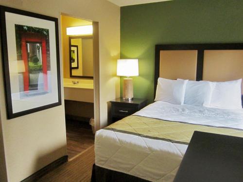 a hotel room with a bed and a lamp at Extended Stay America Suites - Greensboro - Airport in Greensboro