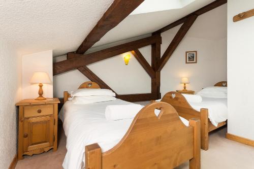deux lits jumeaux dans une chambre avec poutres en bois dans l'établissement Apartment Vila 1 - Cosy Central Chamonix Loft, à Chamonix-Mont-Blanc