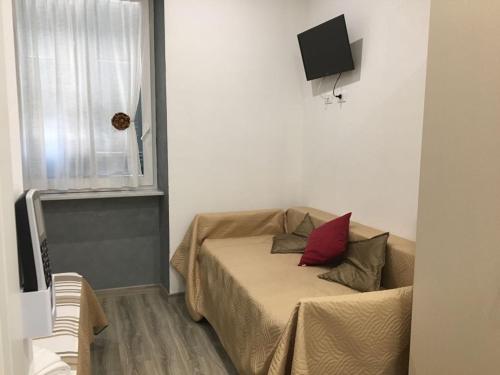 una piccola camera da letto con un letto con un cuscino rosso di La Perla Del Golfo a La Spezia