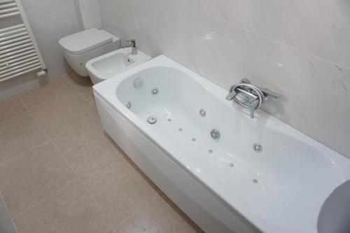 a white bathroom with a tub and a toilet at B & B Nina in Venice