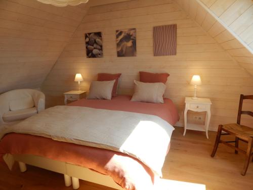 a bedroom with a large bed in a attic at Balade Océane in Loctudy