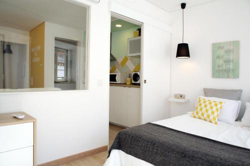 biała sypialnia z łóżkiem i lustrem w obiekcie Alfama Rose Apartment - Elétrico w Lizbonie