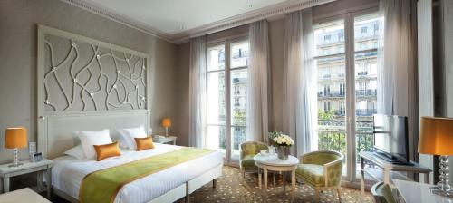a bedroom with a bed and a large window at Splendid Etoile in Paris