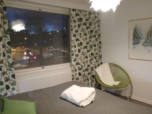 1 dormitorio con cama, ventana y silla en Old Pine Apartment, en Rovaniemi