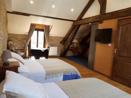 a bedroom with two beds and a cat sitting in the window at Domaine de Vareilles in Vareilles