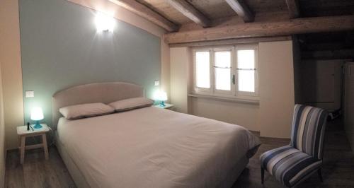 a bedroom with a white bed with two lights on it at Villa Rostagno in Entracque
