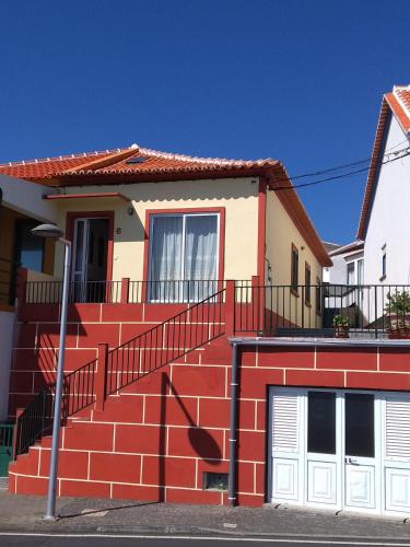 a red and white house with a red staircase at Val's Place in Praia da Vitória
