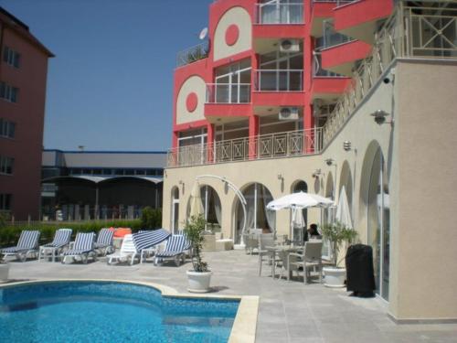 um hotel com piscina e cadeiras e um edifício em Angel Apartment - Kalina Angelova em Sunny Beach