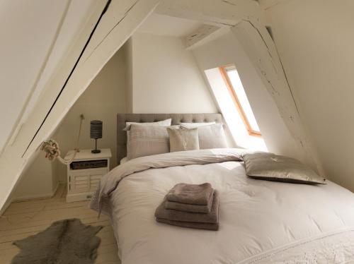 a bedroom with a bed with white sheets and a window at Y & L villa in Antwerp