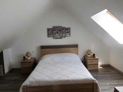 a bedroom with a bed and two night stands at le petit Vauquelin in Sommervieu