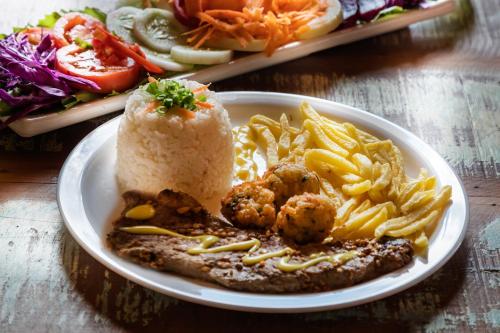 a plate of food with meatballs and pasta on a table at Hotel Fazenda Terra dos Sonhos in Bueno Brandão