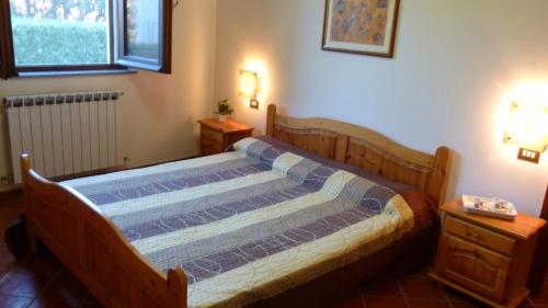 ein Holzbett in einem Zimmer mit zwei Nachttischen in der Unterkunft Appartamenti Albarosa by Holiday World in Sigillo