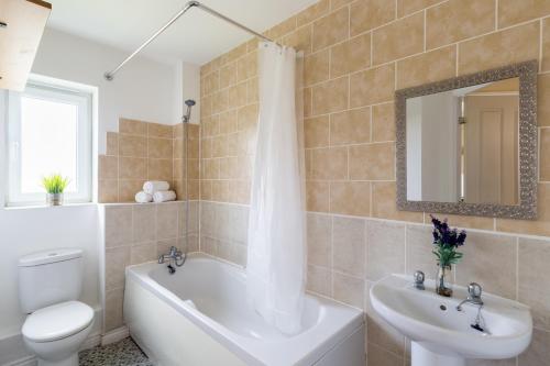 a bathroom with a tub and a toilet and a sink at Wolverhampton City Stay in Wolverhampton