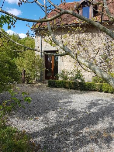 a stone house with a red door and a yard at Domaine de Vareilles in Vareilles